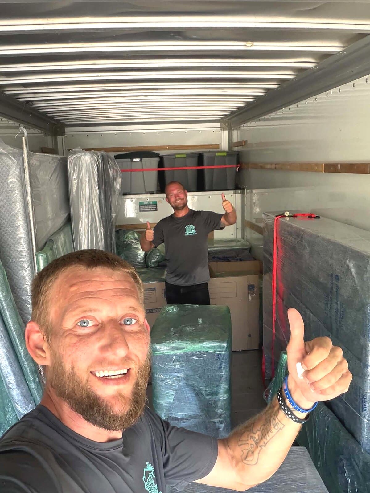 Beach House Moving crew unloading a customer-rented U-Haul packed with blanket-wrapped furniture at RidgeWalk in Santa Rosa Beach, FL
