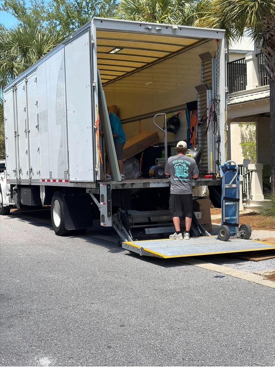 Beach House Moving mover wheeling boxes on a dolly to the truck